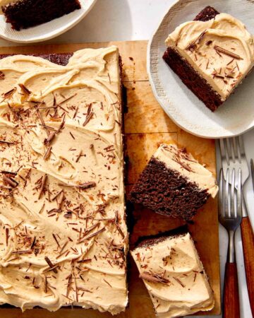 Chocolate sheet cake on a board with slices on the side.