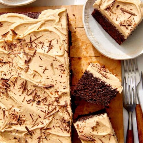 Chocolate sheet cake on a board with slices on the side.