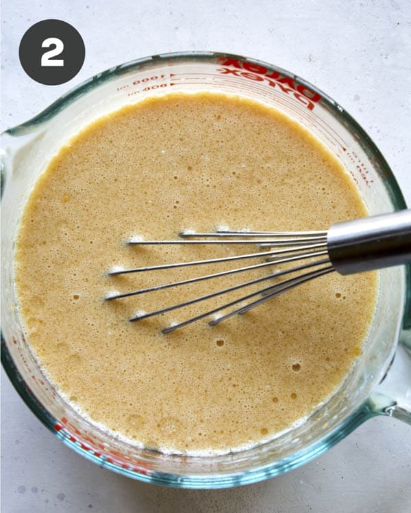 Wet ingredients mixed in a bowl for chocolate sheet cake.