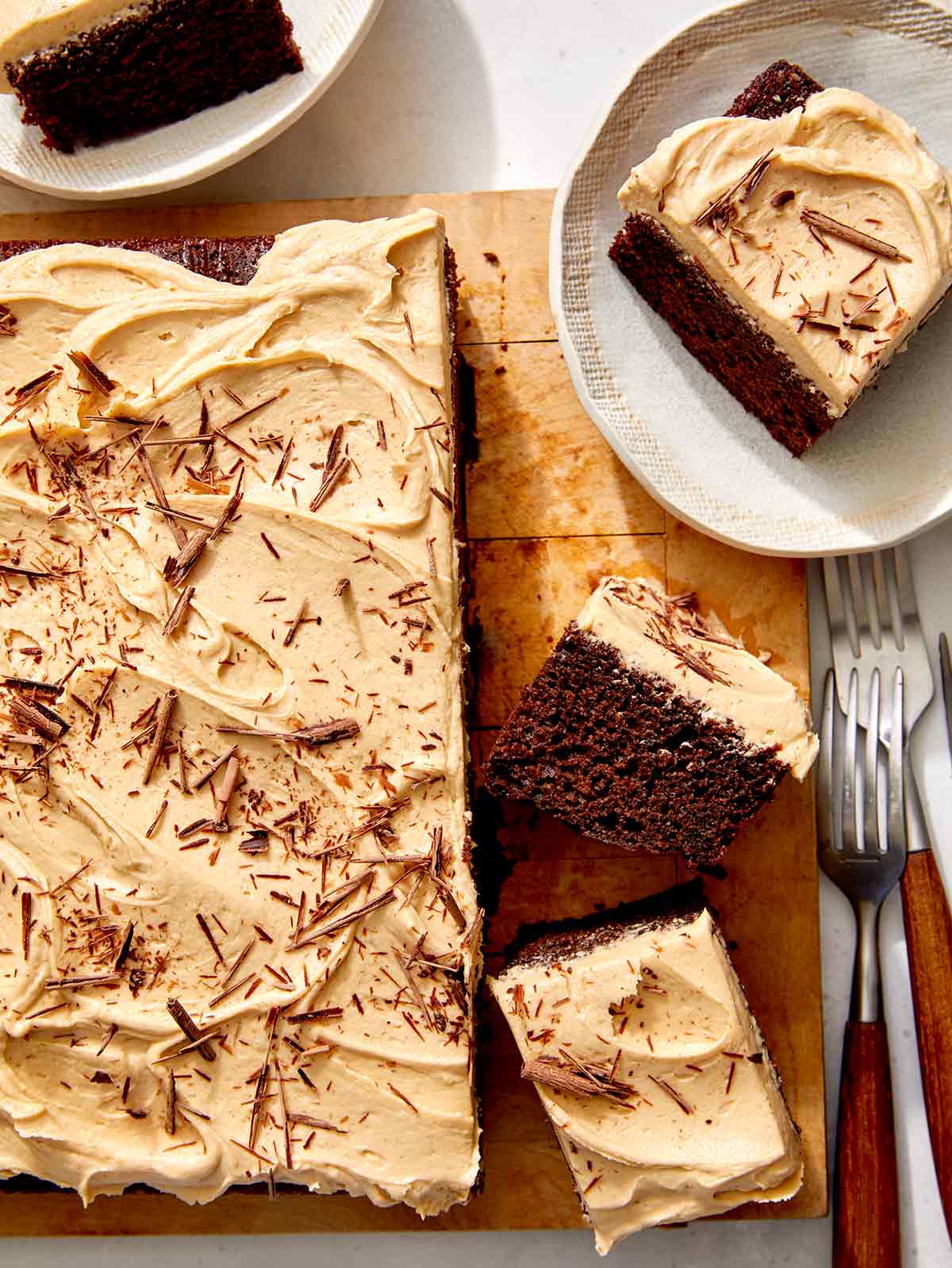 Chocolate sheet cake on a board with slices on the side. 