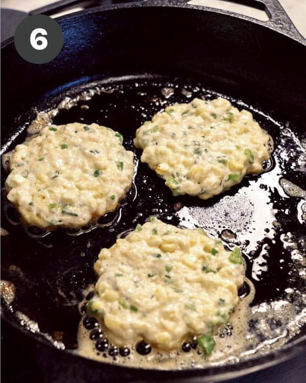 Corn cake batter in a skillet cooking with butter.