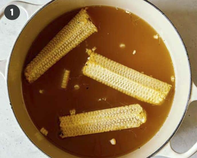 Corn on the cob simmering in stock to make corn chowder. 