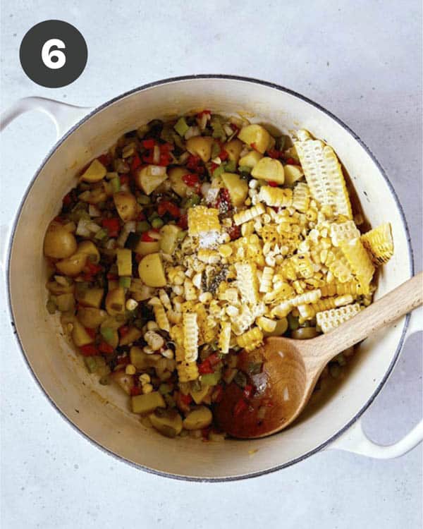 Vegetables and corn in a stock pot cooking for corn chowder.