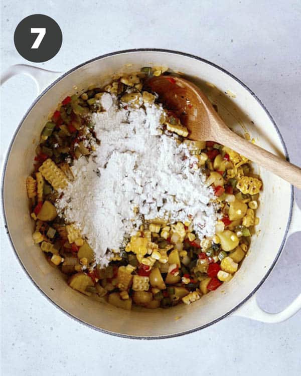 Corn chowder vegetables sprinkled with flour in a pot. 