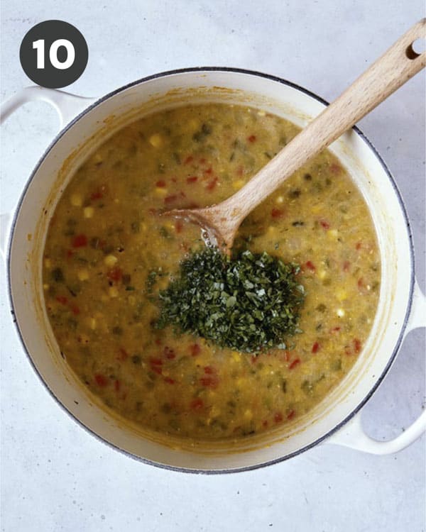 Corn chowder with herbs in a stock pot.