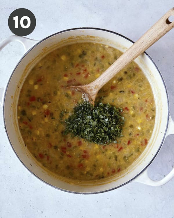 Corn chowder with herbs in a stock pot. 