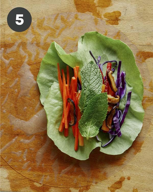 Spring rolls being made with fresh ingredients.