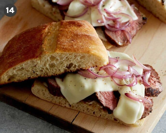 Grilled tri tip sandwich on a cutting board. 