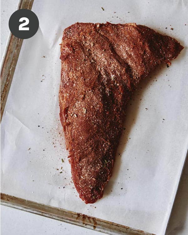 Tri tip covered in a rub to be grilled.
