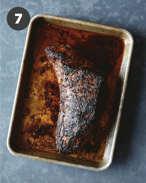 A tri tip that has been freshly grilled resting on a baking sheet. 