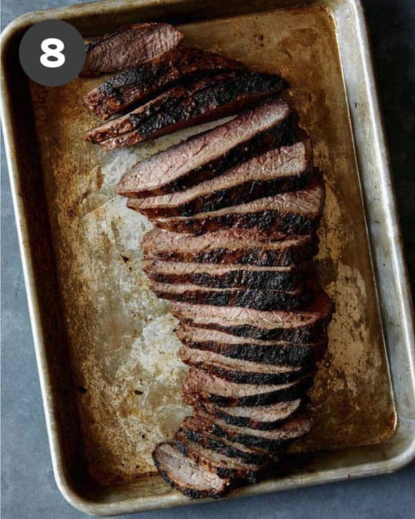 A sliced tri tip on a baking sheet.