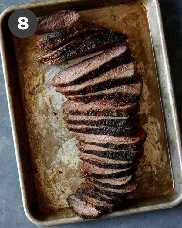 A sliced tri tip on a baking sheet. 