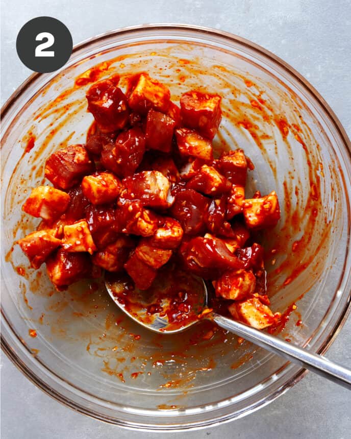 Marinated pork belly in a glass bowl.
