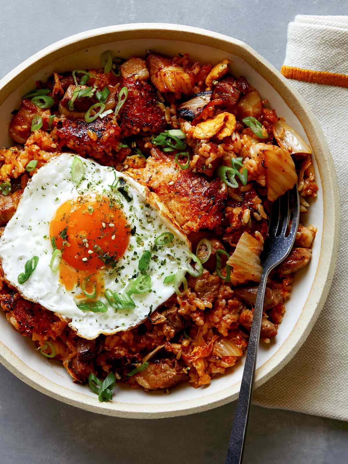 Kimchi fried rice in a bowl with a fork in it. 