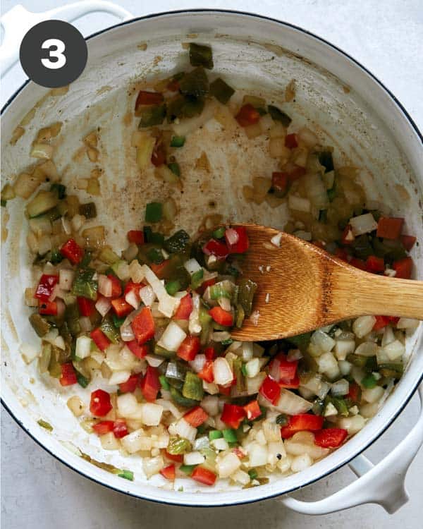 A pot cooking veggies in it for Kitchen Sink Chili. 