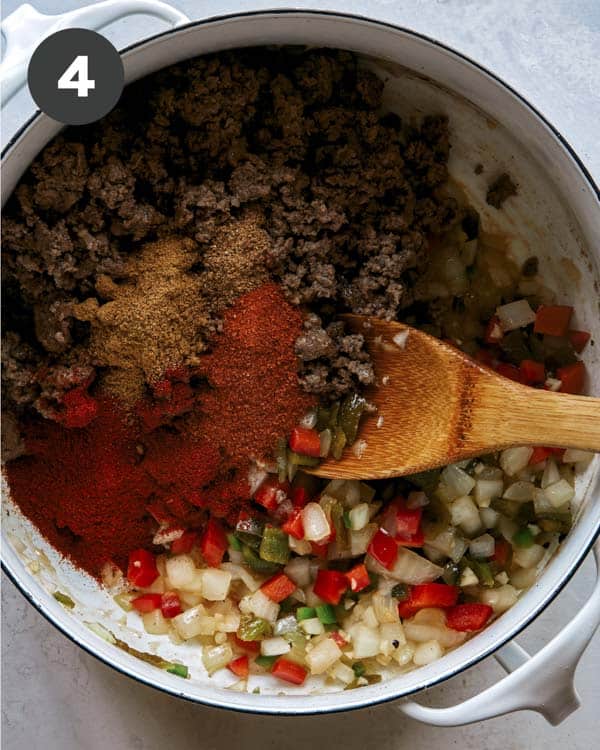 Kitchen sink chili with spices and beef in a pot. 