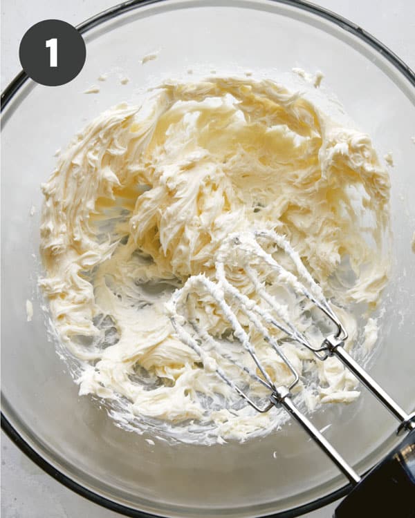Butter being creamed in a glass bowl. 
