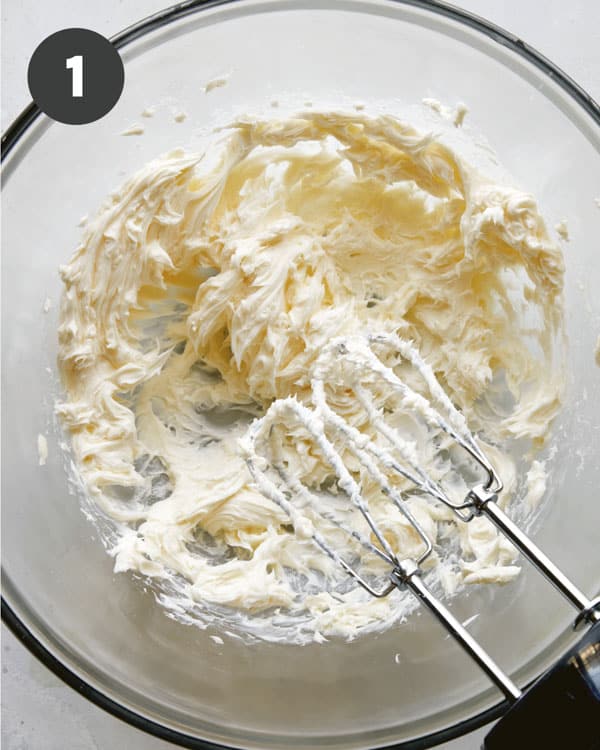 Butter being creamed in a glass bowl.