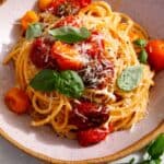Butter roasted cherry tomato pasta with basil on top and parmesan.