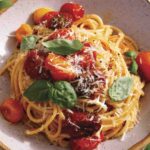 Butter roasted cherry tomato pasta with basil on top and parmesan.