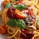 Butter roasted cherry tomato pasta with basil on top and parmesan.