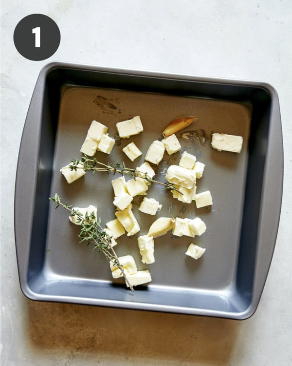 Butter and thyme in a baking dish to roast cherry tomatoes.