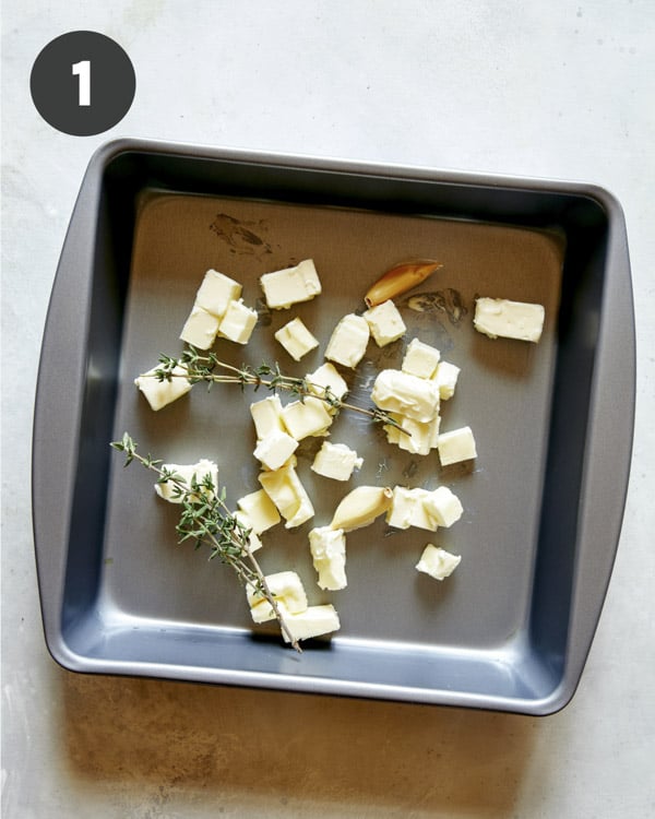 Butter and thyme in a baking dish to roast cherry tomatoes. 