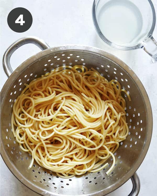 Spaghetti cooked in a collander.