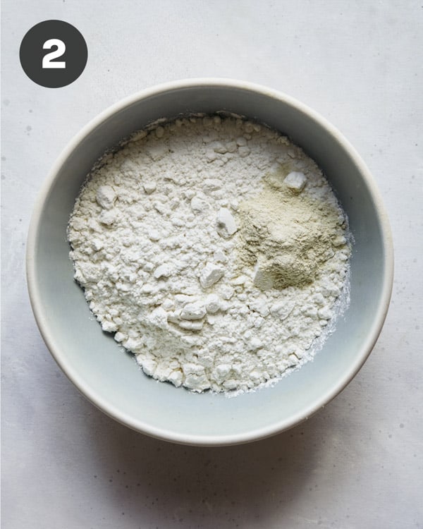 Flour and garlic powder in a bowl for coconut shrimp.