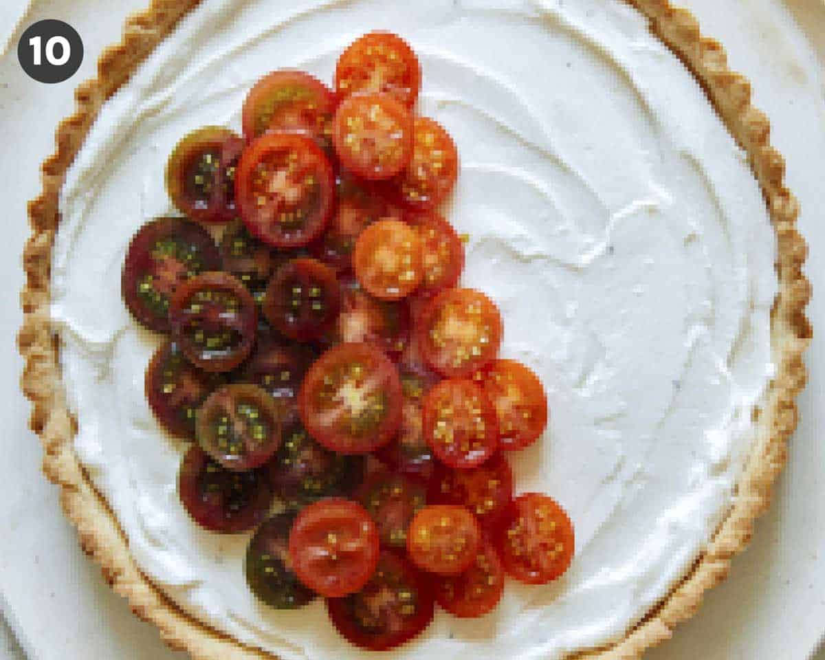 Heirloom tomato tart being filled with tomatoes. 