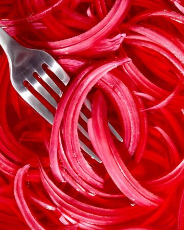 Pickled red onions with a fork in it.