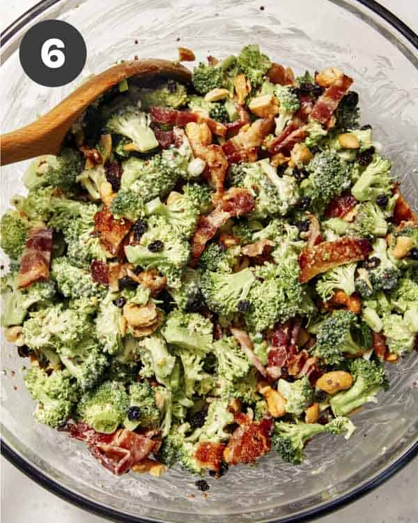Broccoli salad ingredients in a bowl with a spoon. 