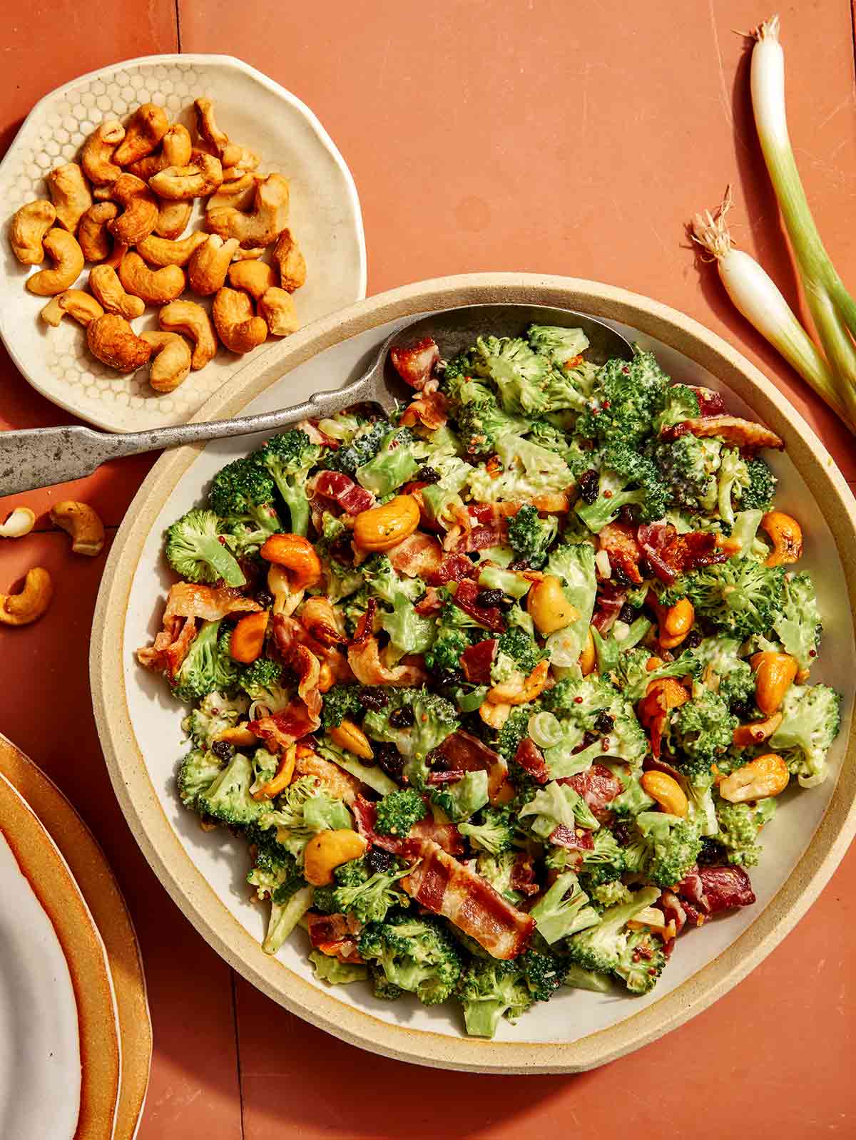 Broccoli salad recipe in a bowl with a spoon in it.