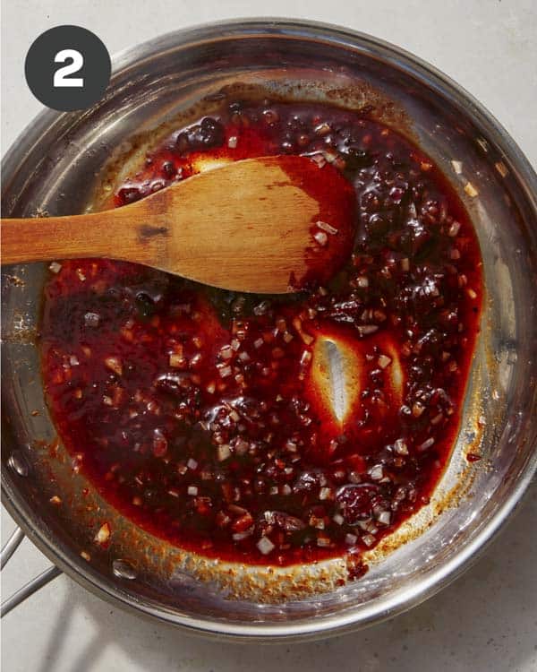 Chipotles in a skillet with shallots. 