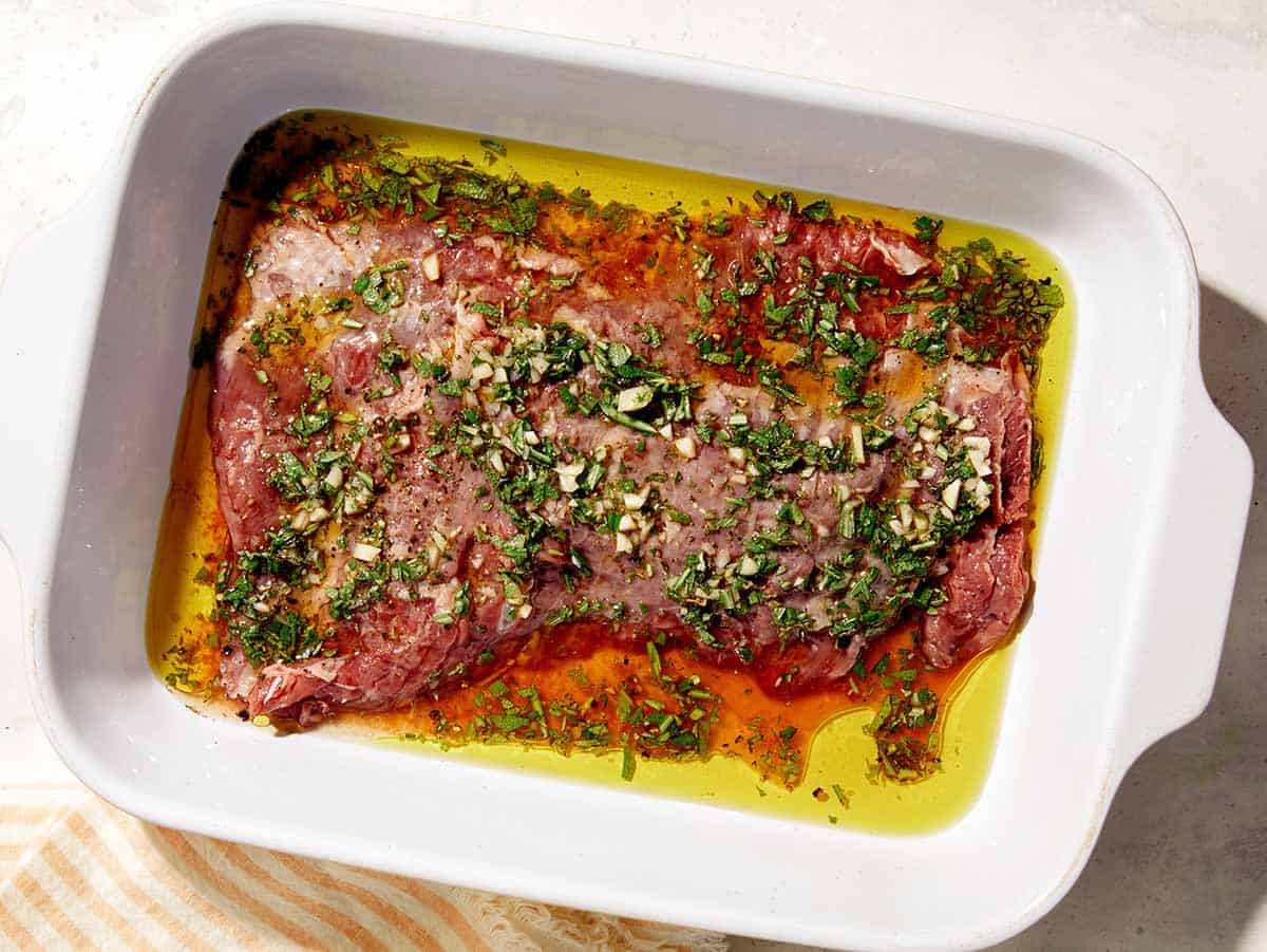 Marinated skirt steak in a baking dish. 