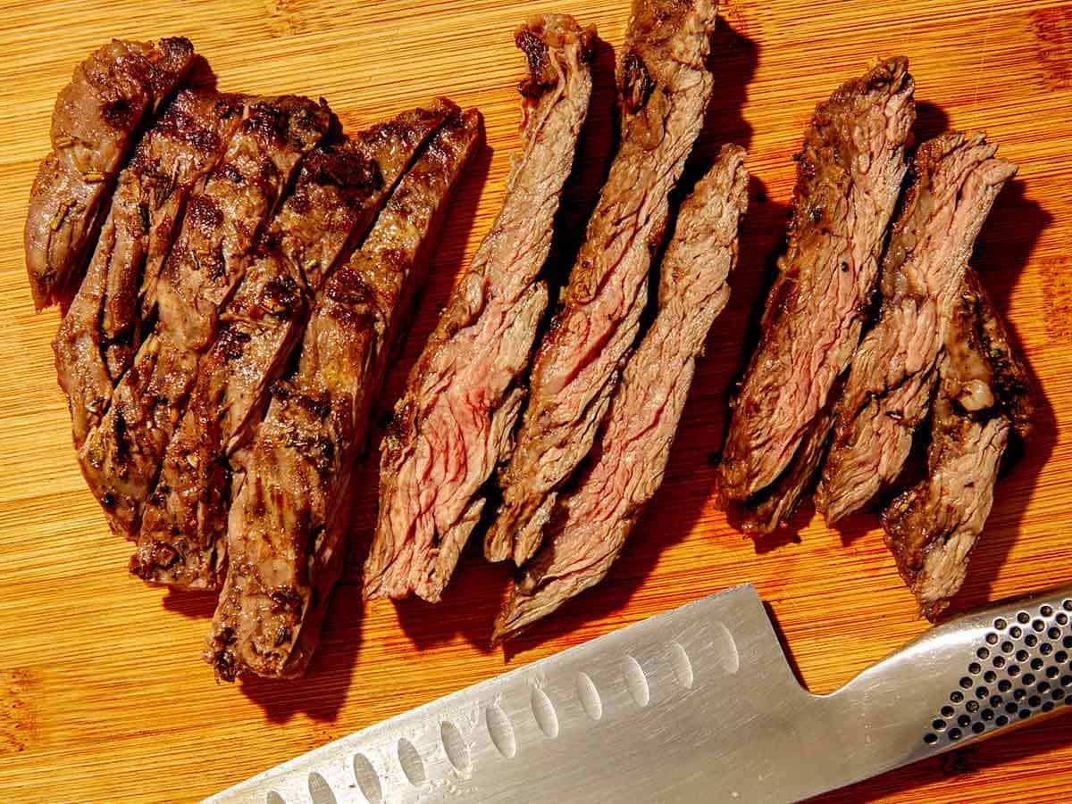 Grilled skirt steak cut on a cutting board. 