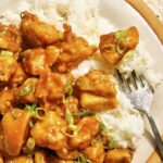 Orange chicken recipe on a plate with rice on the side.
