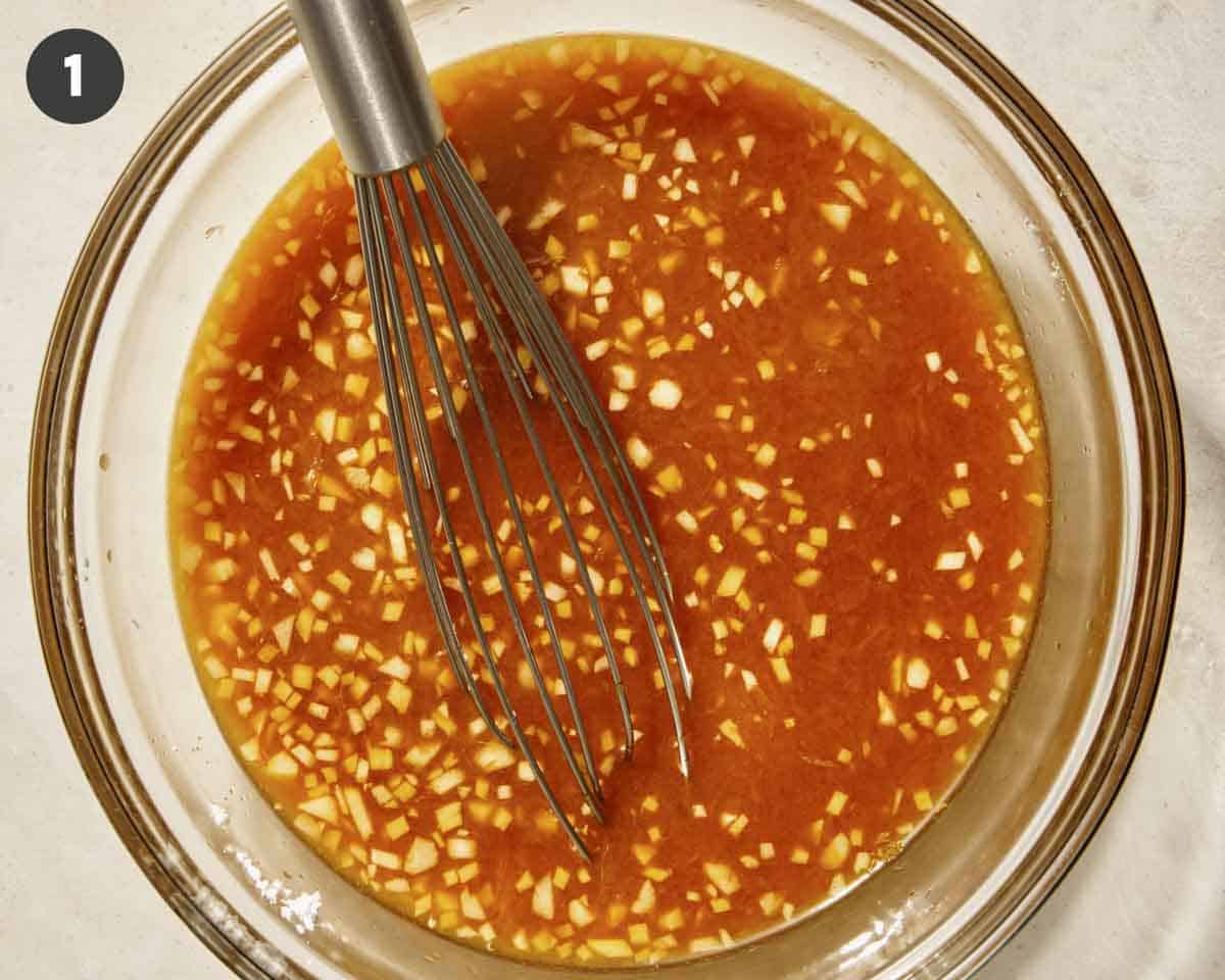 Orange sauce for orange chicken in a glass bowl whisked together. 
