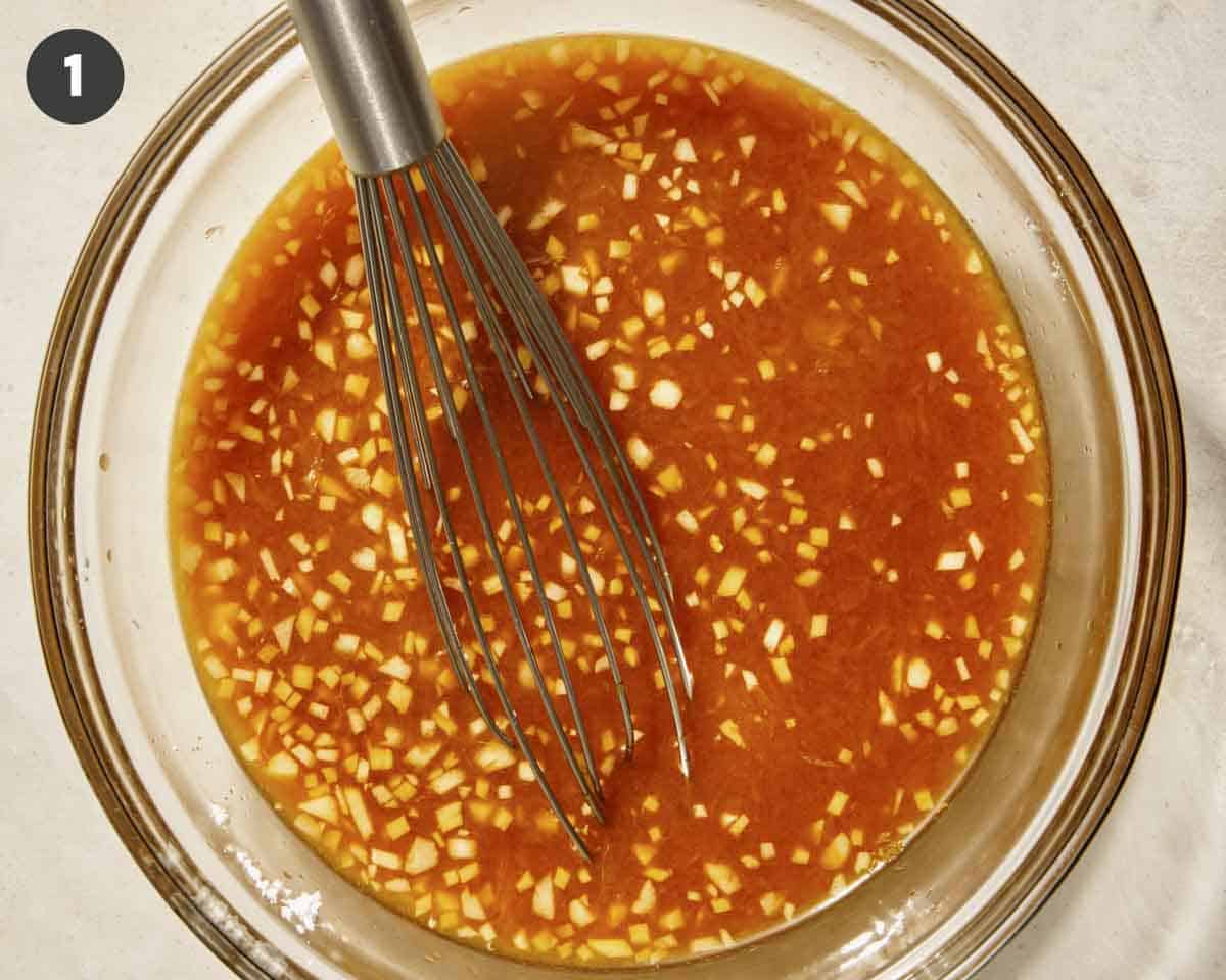Orange sauce for orange chicken in a glass bowl whisked together.