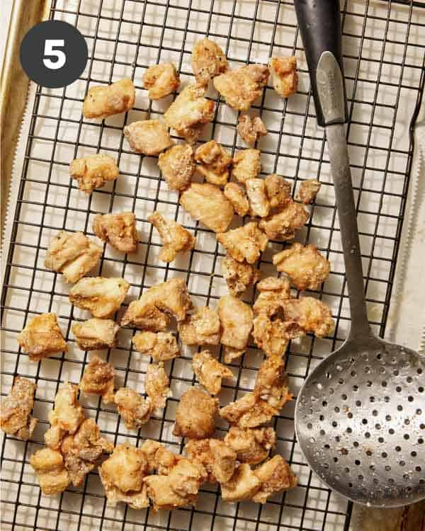 Freshly fried orange chicken on a baking sheet. 