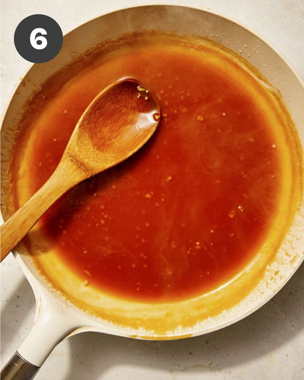 Orange sauce in a saucepan cooking.
