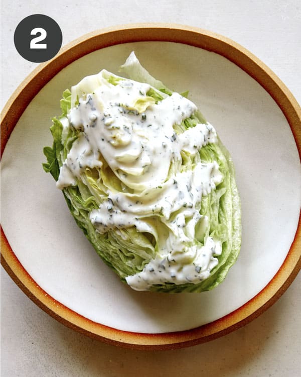 A wedge of lettuce covered in buttermilk ranch. 