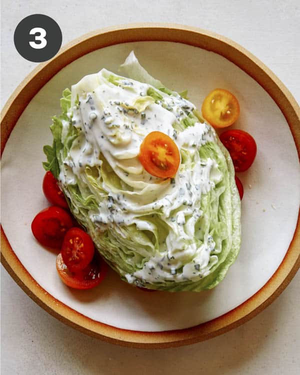 Wedge salad topped with cherry tomatoes. 