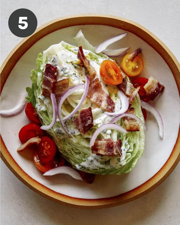 Wedge salad in a bowl with lots of toppings.