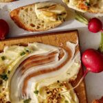 Butter board recipe with bread dipped in it.