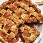 Brown butter apple pie recipe with a cheddar crust and a slice taken out.