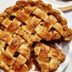 Brown butter apple pie recipe with a cheddar crust and a slice taken out.