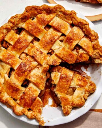 Brown butter apple pie recipe with a cheddar crust and a slice taken out.