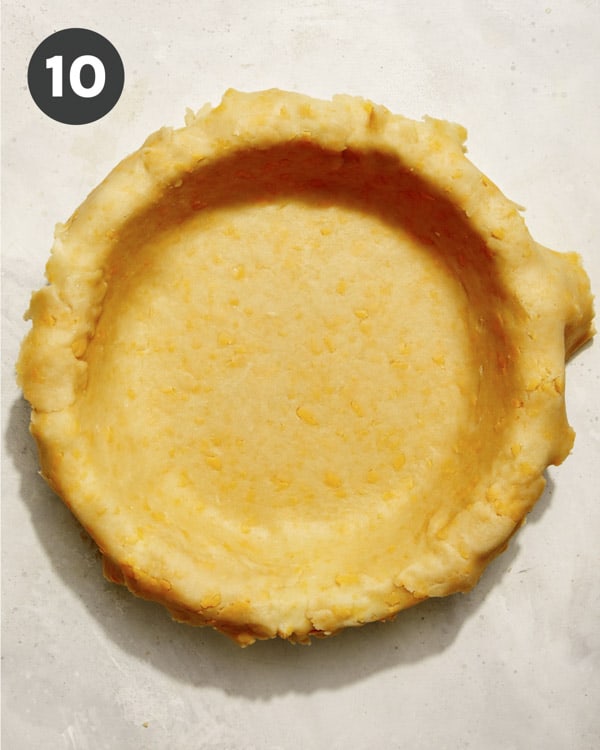 Pie crust being formed in a pie dish. 