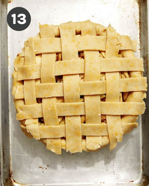 An apple pie on a baking dish pre baked.
